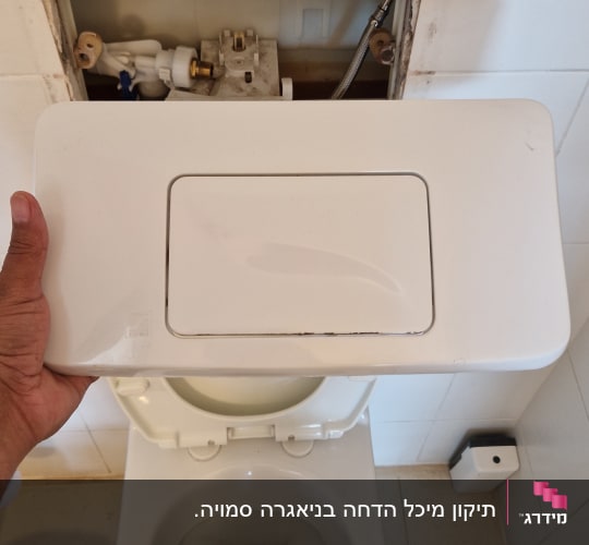 תמונה של אסלה עם מכסה פתוח ותיקון צנרת
